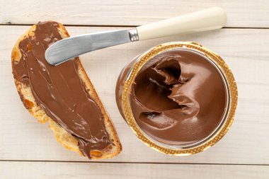 Cam bir kavanozda çikolata ezmesi, ahşap bir masa, üst manzara, makro.