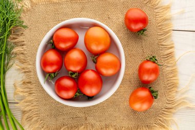 Ahşap bir masada jüt peçeteli taze domatesler, üst manzara, yakın çekim..