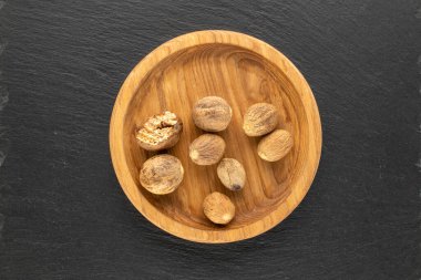 Tahta bir tabağın içindeki Nutmeg tahta bir taş, makro, üst görünüm.