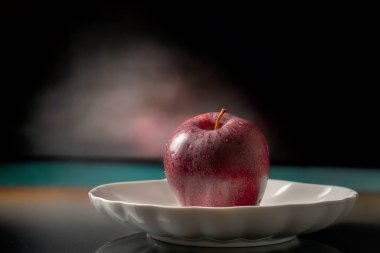 Arkaplanda seramik bir tabakta elmalar, yakın plan..
