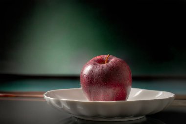 Arkaplanda seramik bir tabakta elmalar, yakın plan..