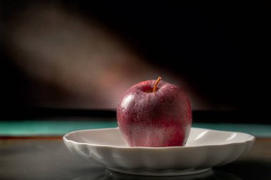Arkaplanda seramik bir tabakta elmalar, yakın plan..