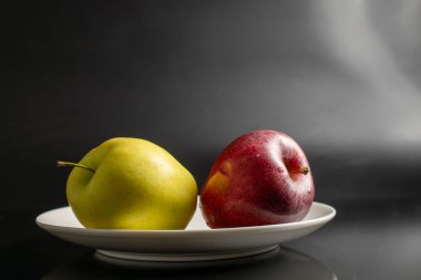 Arkaplanda seramik bir tabakta elmalar, yakın plan..