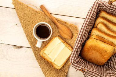 Tereyağlı tost ekmeği ve ahşap bir masada bir fincan kahve, yakın plan, üst manzara..