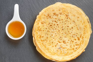 Tatlı krepler kayrak taşı üzerinde bal ile, üst görünüm, makro.