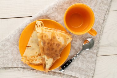 Gövde üzerinde tatlı gözlemeler, ahşap bir masada fincan, üst manzara, yakın çekim..