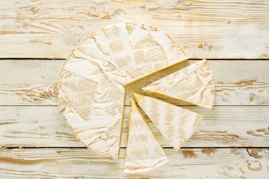 Ahşap bir masanın üzerinde mutfak aletleri olan peynirli peynir, yakın plan. Üst görünüm.