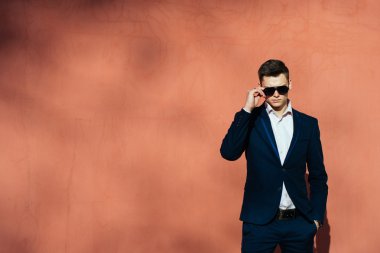 bir tuğla duvar bir arka plan üzerinde siyah elbiseli genç adam