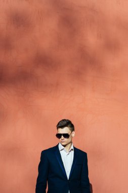 bir tuğla duvar bir arka plan üzerinde siyah elbiseli genç adam