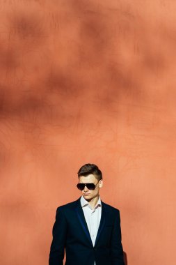 bir tuğla duvar bir arka plan üzerinde siyah elbiseli genç adam