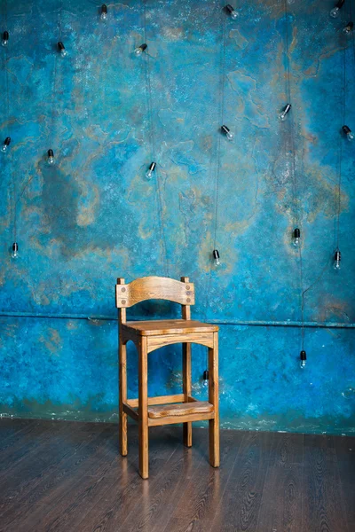 Old wooden chair in grunge room with blue wall