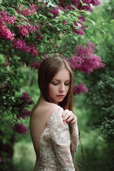 Belle jeune fille dans un lilas fleuri — Photo