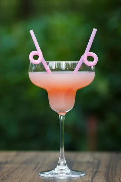 Склянка у формі рожевого грейпфрута на зеленому фоні боке — стокове фото