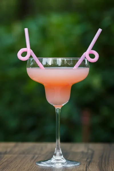 Gevormde glas met roze pompelmoes cocktail op groene achtergrond bokeh — Stockfoto