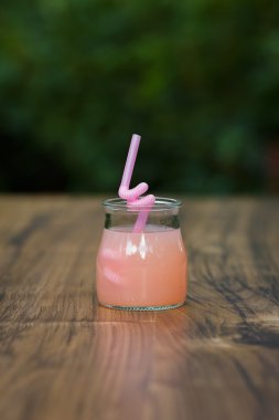 Pembe greyfurt yeşil arka plan bokeh kokteyl ile jar