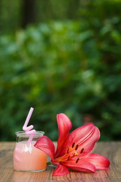 Słoik z różowego grejpfruta koktajl na zielonym tle bokeh — Zdjęcie stockowe