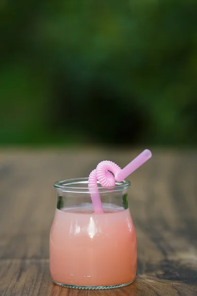 JAR s růžového grepu koktejl na zeleném pozadí bokeh — Stock fotografie
