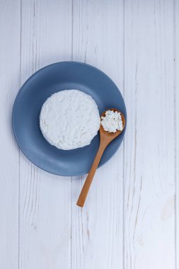 Tahta kaşıkla tabakta taze çiftlik yapımı süzme peynir..