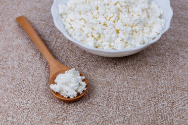 Tahta kaşıkla kasede taze çiftlik peyniri..