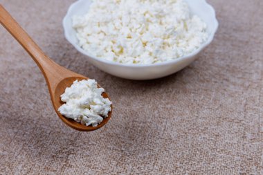 Tahta kaşıkla kasede taze çiftlik peyniri..