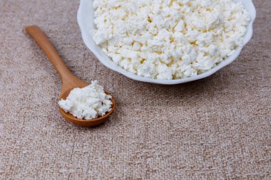 Tahta kaşıkla kasede taze çiftlik peyniri..