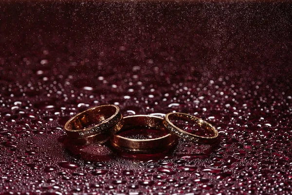Anéis Casamento Superfície Água Escura Brilhando Com Luz Chuva Gotas — Fotografia de Stock
