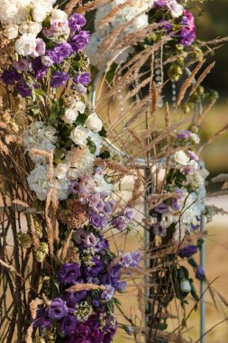 Düğün merasimi yeri. Güzel yeşil bir parkta, taze çiçeklerle süslenmiş düğün kemeri..