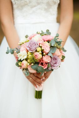 Gelin elinde çiçek buketini, düğün çiçeğini tutuyor.