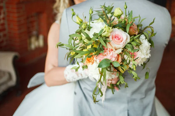 La mariée tient le bouquet de fleurs dans sa main, le bouquet floral de mariage — Photo