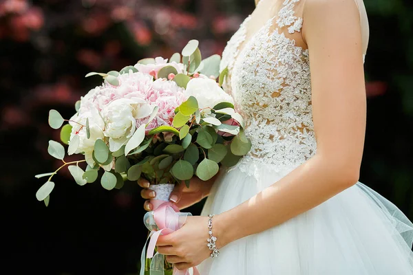 A noiva segura o buquê de flores em sua mão, o buquê floral do casamento — Fotografia de Stock