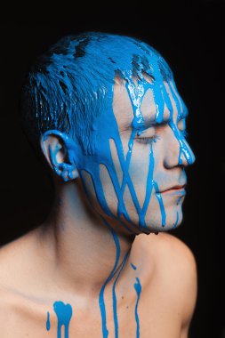 Yakın çekim portre onun yüzünde boya ile genç yakışıklı erkek modeli