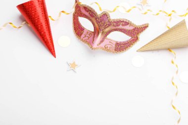 Beyaz arkaplanda karnaval maskesi ve konfeti kopyalama alanı düzdü