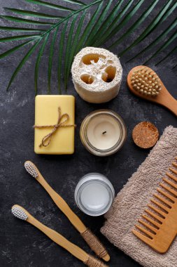 Doğal bambu diş fırçaları, siyah diş tozu, siyah arka planda saç tarağı, sabun ve sünger, sıfır atık ürünü, doğal ağız temizliği, kopyalama alanı