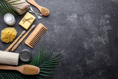 Doğal bambu diş fırçaları, siyah diş tozu, siyah arka planda saç tarağı, sabun ve sünger, sıfır atık ürünü, doğal ağız temizliği, kopyalama alanı