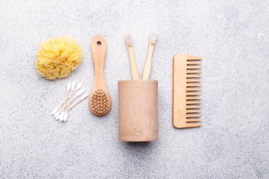 Sıfır atık yeniden kullanılabilir banyo öğeleri doğal taş arka plan, ahşap tarak, diş fırçası, deniz süngeri, kulak çubuğu, katı sabun, düz yatak