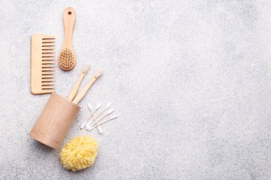 Sıfır atık yeniden kullanılabilir banyo öğeleri doğal taş arka plan, ahşap tarak, diş fırçası, deniz süngeri, kulak çubuğu, katı sabun, düz yatak