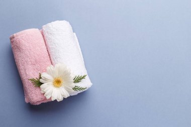 Gri arka planda kaplıca, aromaterapi sağlık ve sağlık, fotokopi alanı düzlüğü, pembe ve beyaz havlular ve çiçek.