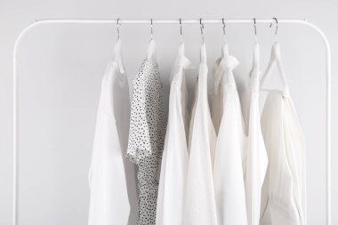 White spring summer female clothes hanging on a rack in a shop