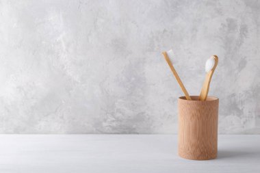 Gri taş arka planda doğal bambu diş fırçaları, sıfır atık ürün, doğal ağız hijyeni.