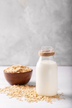 Vegan sigara süt yulaf süt un ve beyaz ahşap arka plan sağlıklı beslenme üzerinde pul