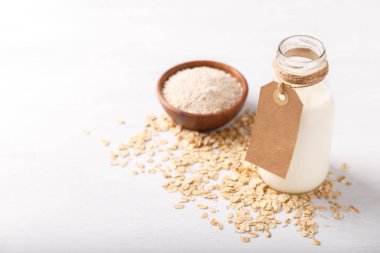 Vegan sigara süt yulaf süt un ve beyaz ahşap arka plan sağlıklı beslenme üzerinde pul