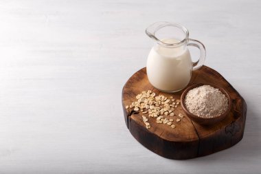 Vegan sigara süt yulaf süt un ve beyaz ahşap arka plan sağlıklı beslenme üzerinde pul