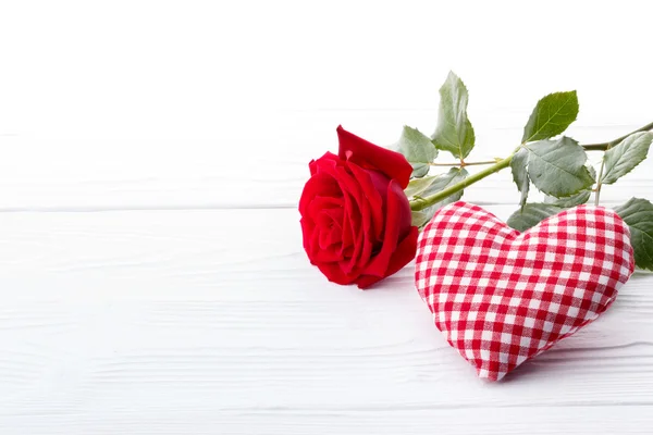 Rosa vermelha e um coração no fundo branco — Fotografia de Stock