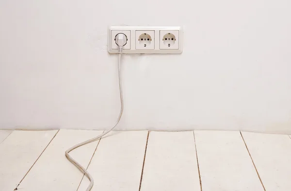 Tres enchufes eléctricos blancos con cable de alimentación blanco —  Fotos de Stock