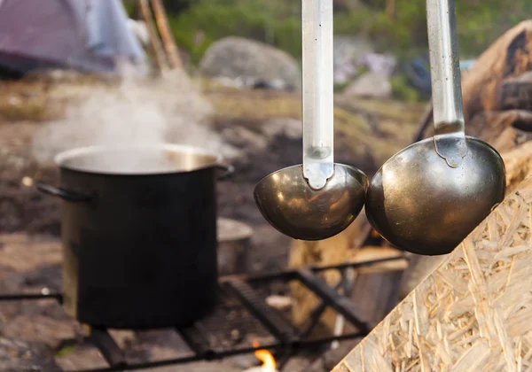 Yemek yemek doğada. Buhar ve yanan orman kepçe ile büyük pot.
