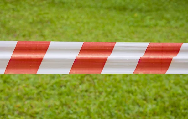 Yeşil çim zemin üzerine kırmızı ve beyaz uyarı teyp