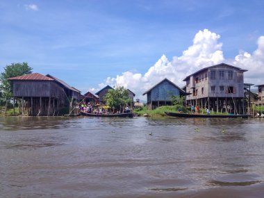Inle Gölü, Myanmar - 26 Nisan 2014: Yerel longtail tekne yüzen köyün Inle Gölü, Myanmar, önünde insanlar