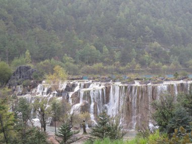 Beyaz su nehir şelale kayalıklarla ve brooks jade dragon snow mountain, lijiang, yunnan Çin'ın eteklerinde