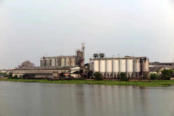 Usine et silo près de la rivière — Photo