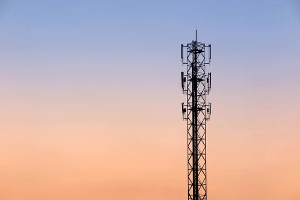 Telecommunication cellular tower on twilight background